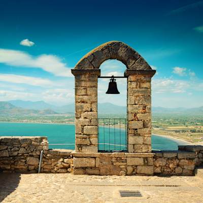An ancient Greek archway frames the Nafplio coast in Greece