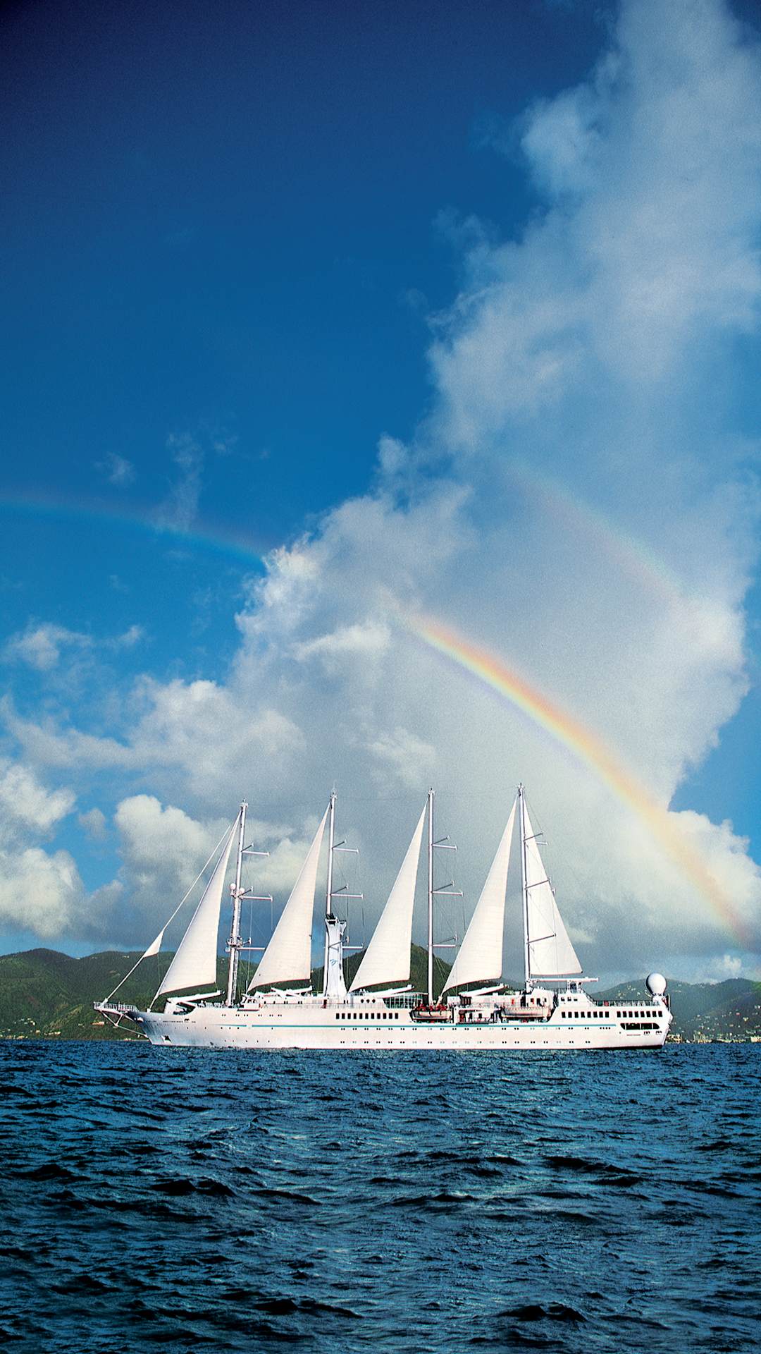 rainbow over sailing yacht