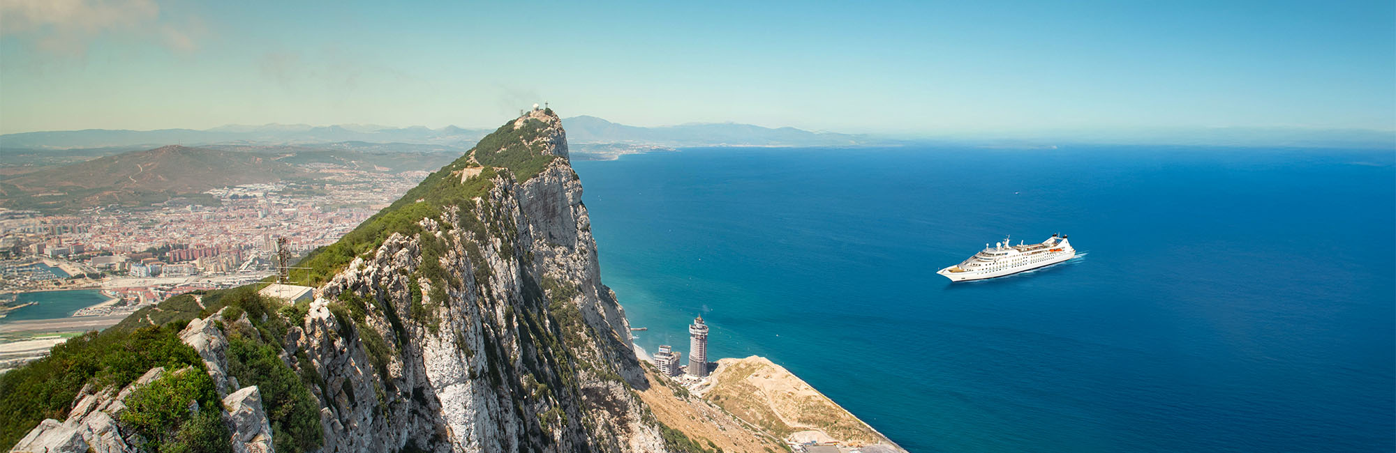 Luxury yacht sailing through Mediterranean waters at sunset